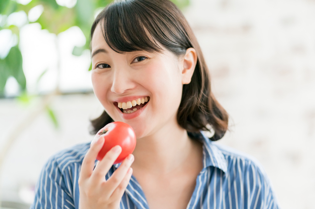 トマトを食べる女性