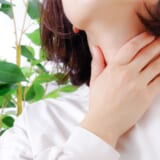 喉をおさえる女性