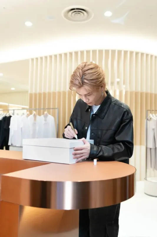 白い箱にサインをしている岩田剛典さん